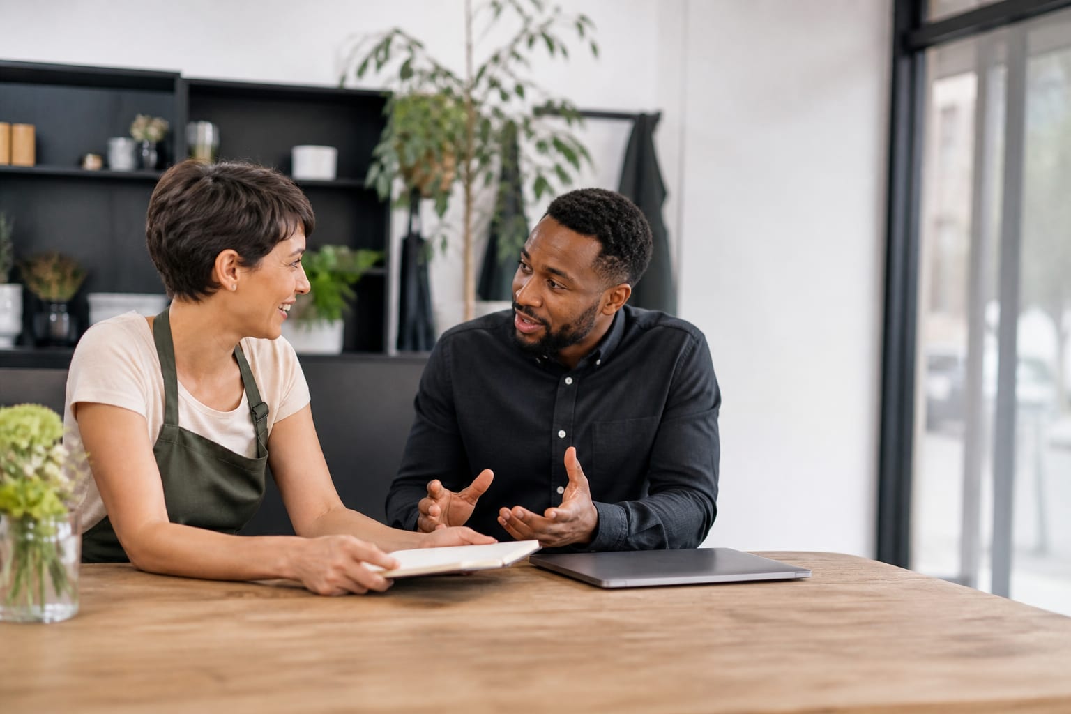 Two people discussing a website project at a table